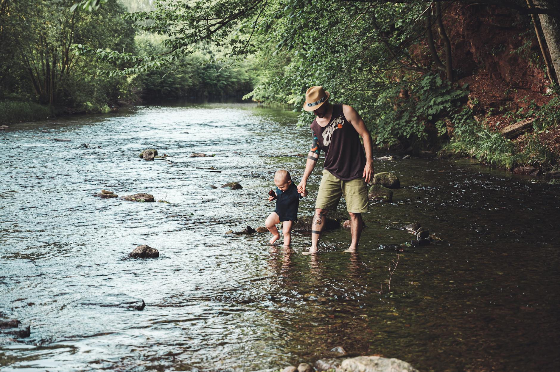 Parent and child wading in the creek