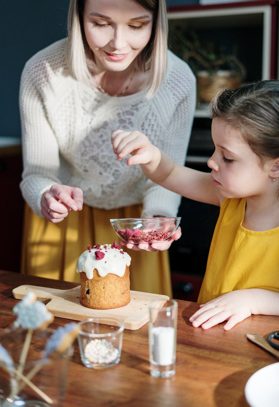 Mother and child decorating a small cake together