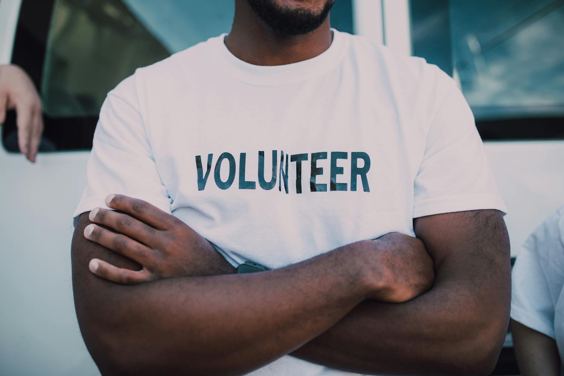 A fit-looking man wears a tee-shirt that reads "volunteer"